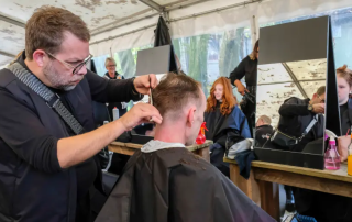 Gut essen im Abseits am Büdchen in Osnabrück- ein Wohnungsloser wird von einem Stylisten frisiert.