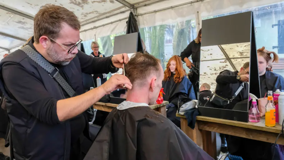 Gut essen im Abseits am Büdchen in Osnabrück- ein Wohnungsloser wird von einem Stylisten frisiert.